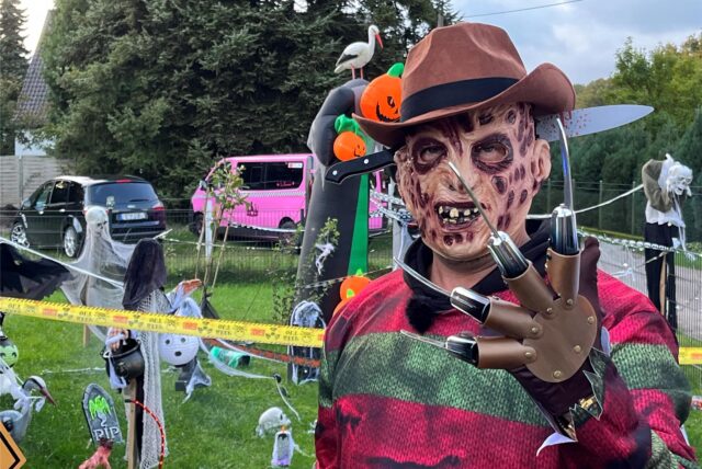 Eine Halloween-Figur mit zerrissenen und dreckigen Kleidern, einem Hut auf dem Kopf, einer Maske im Gesicht und Messerklingen an den Fingern steht einem Garten in Dorsten.