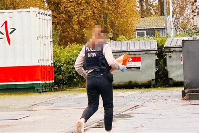 Eine Polizistin läuft über das Gelände einer Tankstelle.