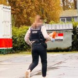 Eine Polizistin läuft über das Gelände einer Tankstelle.
