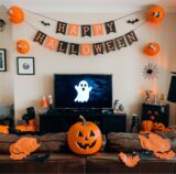 Ein Wohnzimmer ist für Halloween dekoriert. Im Fernsehen läuft ein Halloween-Film.