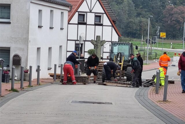 Arbeiter nehmen Straßenpflaster auf