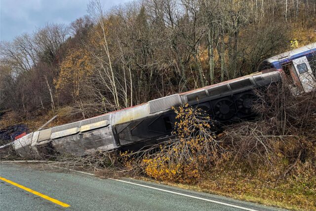 Ein entgleister Zug ist zwischen den Bäumen zu sehen. Bei der Entgleisung eines Zuges am Finneidfjord im norwegischen Nordland sind am Mittwochnachmittag mehrere Menschen verletzt worden, teilte die Polizei mit. Die Entgleisung wurde wahrscheinlich durch einen Felssturz verursacht.
