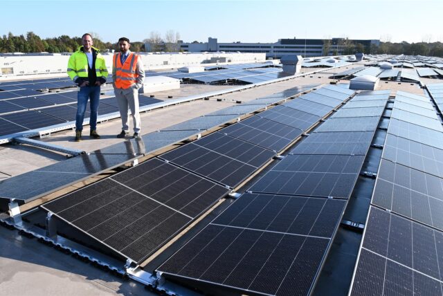 Thomas Gries (Standortleiter) und Kaan Mertens (zuständig für die Installation von PV-Anlagen) stehen auf dem Dach des DHL-Paketzentrums in Dorsten