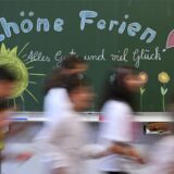 Zu Beginn der Herbstferien in NRW Schulkinder laufen an der Tafel vorbei.