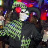 Ein Harlekin mit Totenschädel auf einer Halloween-Party