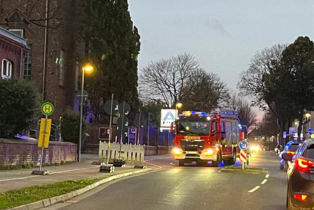 Ein Feuerwehrfahrzeug steht auf der Straße an der Maschinenhalle in Scherlebeck.