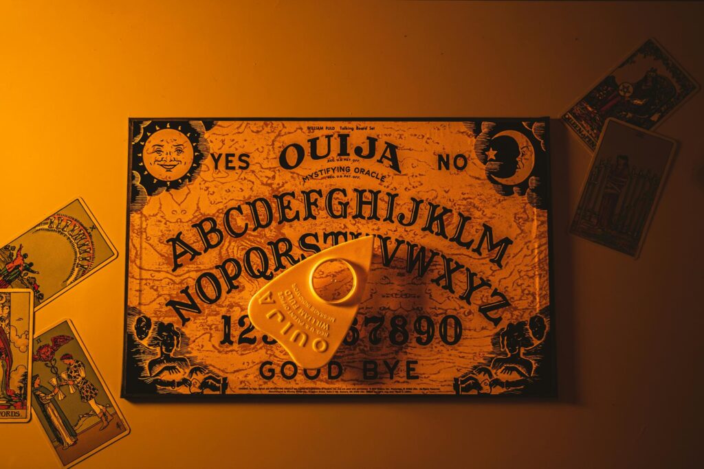 Bei einer Halloween-Party liegen ein Ouija-Brett und Tarotkarten auf dem Tisch. Bei einer Halloween-Party liegen ein Ouija-Brett und Tarotkarten auf dem Tisch.