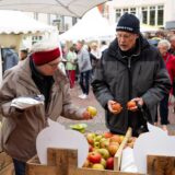 Ein Ehepaar steht beim Gänsemarkt in Haltern an einem Marktstand, an dem Äpfel angeboten werden.