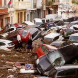 Anwohner betrachten durch die Wassermassen aufgestapelte Autos nach dem fürchterlichen Unwetter in Spanien.