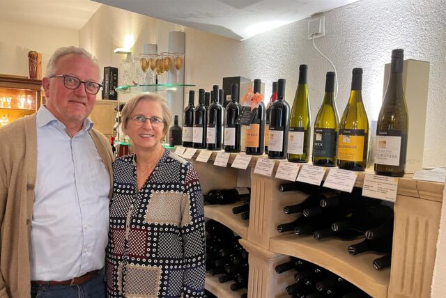 Ludger und Susanne Kerkmann stehen vor einem Weinregal.