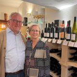 Ludger und Susanne Kerkmann stehen vor einem Weinregal.