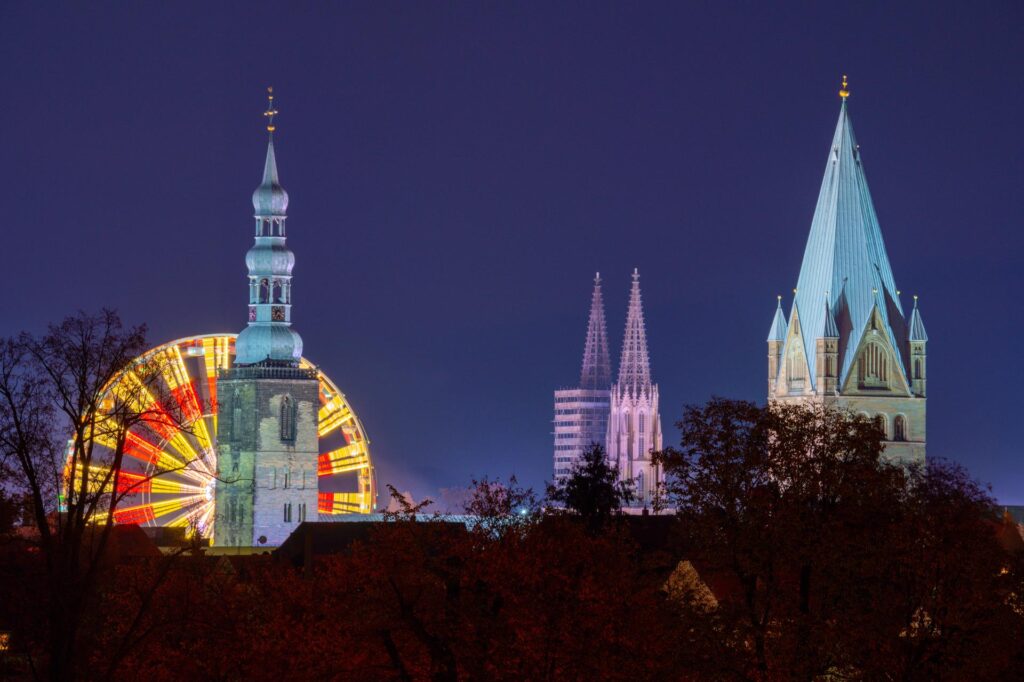 Ein Riesenrad ist während der Allerheiligenkirmes in Soest neben den Kirchtürmen von Petrikirche, Wiesenkiche und St.-Patrokli-Dom zu sehen. Ein Riesenrad ist während der Allerheiligenkirmes in Soest neben den Kirchtürmen von Petrikirche, Wiesenkiche und St.-Patrokli-Dom zu sehen.