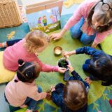 Eine Betreuerin spielt mit Kindern in einer Kita