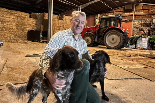 Hubert Stoffers, Vorsitzender des Hegerings Herten, hockt neben seinen zwei Hunden.