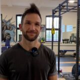 Dominik Schulte-Sasse steht in einem der Krafträume der Kraftkaue in Herten. Im Hintergrund sind verschiedene Geräte und Gewichte aufgestellt.