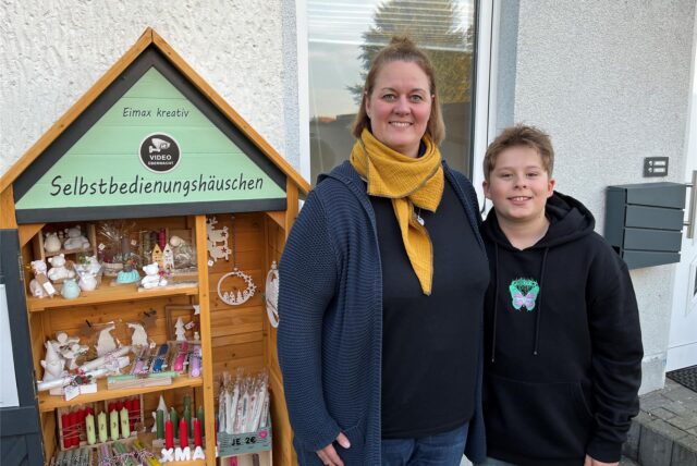 Eileen und Maximilian Rusche stehen vor dem Deko-Selbstbedienungshäuschen in Oer-Erkenschwick.