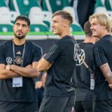 Emre Can, Nico Schlotterbeck und Julian Brandt stehen in einem Stadion.