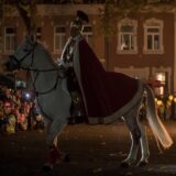 Der „Heilige Sankt Martin“ teilt im Anschluss an einen Martinsumzug seinen Mantel mit einem „Bettler“.