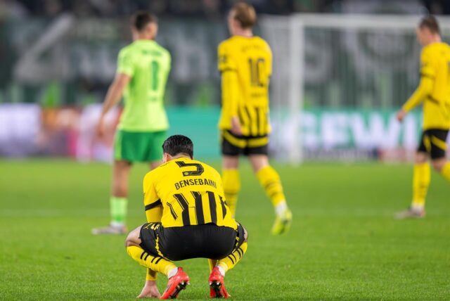 Ramy Bensebaini kauert auf dem Rasen.