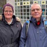 Das Ehepaar Kentschke steht vor dem Glashaus in Herten. Im Hintergrund sind die Luftballon-Buchstaben der Stadtbibliothek zu sehen. Beide tragen eine Jacke und lächeln in die Kamera.