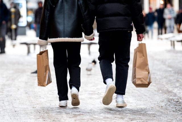 Passanten mit Einkaufstüten in der Hand gehen am verkaufsoffenen Sonntag durch die Innenstadt.