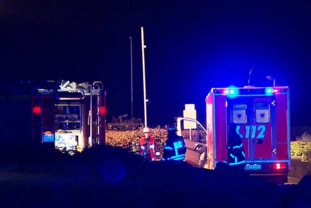 Einsatzfahrzeuge der Feuerwehr und des Rettungsdienstes stehen während eines Einsatzes in einer Kleingartenanlage in Dortmund.