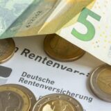 Münzen und eine Banknote liegen auf einer Renteninformation der Deutschen Rentenversicherung.