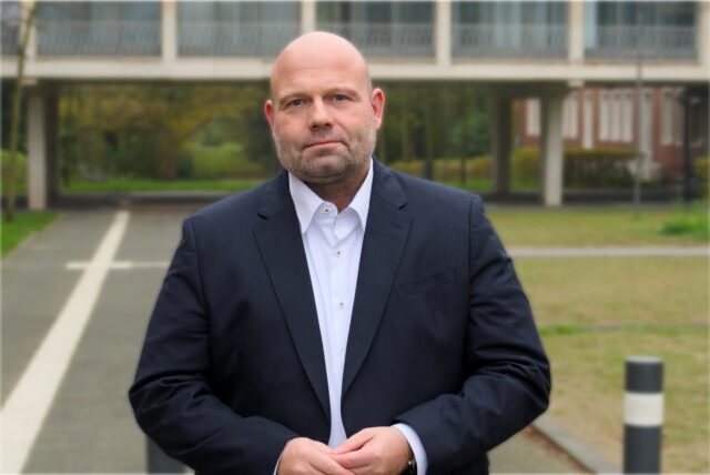 Hertens Stadtkämmerer Dr. Oliver Lind steht mit ernster Miene vor dem Rathaus.