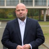 Hertens Stadtkämmerer Dr. Oliver Lind steht mit ernster Miene vor dem Rathaus.
