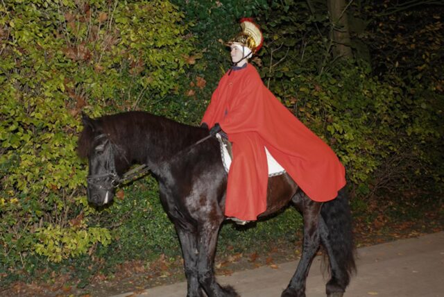 St. Martin sitzt  auf einem schwarzen Pferd.