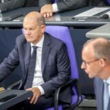 Olaf Scholz sitzt im Bundestag, im Anschnitt Friedrich Merz.