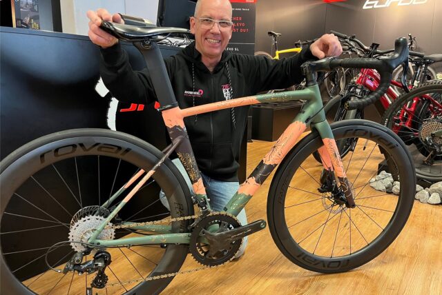 Michael Benthaus kniet an einem Fahrrad.