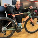 Michael Benthaus kniet an einem Fahrrad.