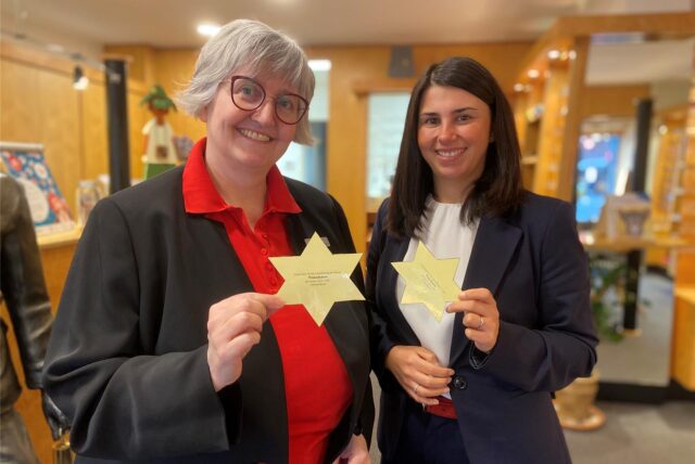 Petra Hagemann (links) und Yasemin Breilmann halten jeweils einen Wunschstern hoch.