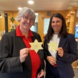 Petra Hagemann (links) und Yasemin Breilmann halten jeweils einen Wunschstern hoch.