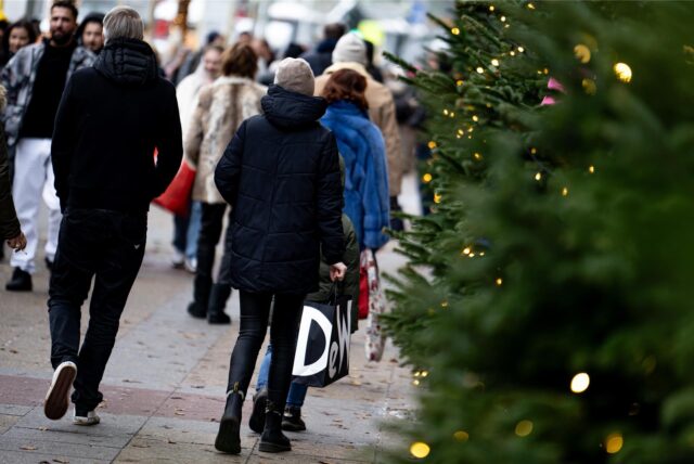 Menschen gehen mit Einkaufstüten am verkaufsoffenen Sonntag in NRW einkaufen.