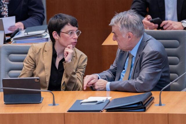Herbert Reul (CDU), Innenminister von Nordrhein-Westfalen, und Josefine Paul (Bündnis 90/Die Grünen), Ministerin für Kinder, Jugend, Familie, Flucht und Integration in Nordrhein-Westfalen, unterhalten sich im Plenum des Landtags.