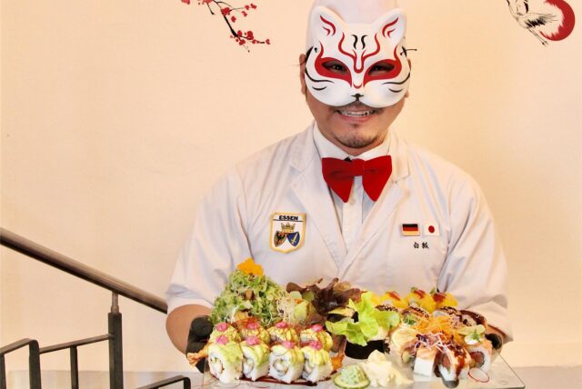 Masanori „Fox“ Takase steht mit seinem „Rüttenscheid“-Set unter Kirschblütendesign im Restaurant „Byakko“ in Essen-Rüttenscheid.