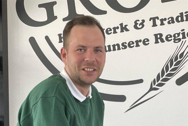 Backstuben-Leiter Chris Hoffmann des Familienunternehmens Bäckermeister Grobe sitzt auf einem Tisch.