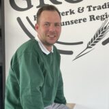 Backstuben-Leiter Chris Hoffmann des Familienunternehmens Bäckermeister Grobe sitzt auf einem Tisch.