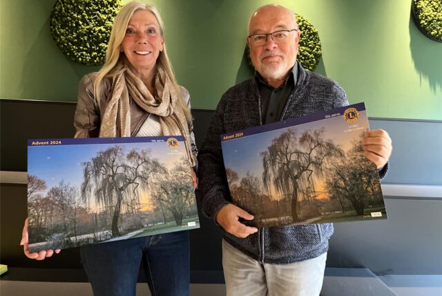 Elke Fleckhaus und Karl-Heinz Dargel zeigen den Adventskalender 2024 der Lions Clubs Marl.