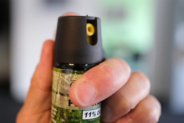 Eine Hand hält eine Kartusche mit Pfefferspray.