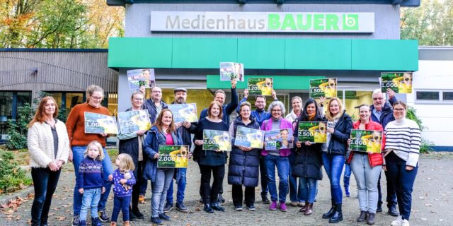 Gruppenbild mit symbolischen Schecks vor dem Medienhaus Bauer in Marl.