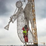 Arbeiter befestigen in luftiger Höhe den Engel auf dem großen Weihnachtsbaum in Dortmund.