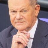 Bundeskanzler Olaf Scholz (SPD) sitzt vor seiner Regierungserklärung im Plenum des Bundestags auf der Regierungsbank.