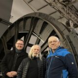 Vor der riesigen Treibscheibe der Fördermaschine der ehemaligen Schachtanlage Auguste Victoria 4 in Drewer stehen (v.l.) Johannes Jansen, Michael Heyder und Alfred Dodot.