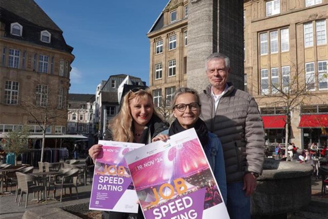 Ariane Hohengarten (Agentur für Arbeit) und Nina Jordan (Gleichstellungsbeauftragte) halten vor dem Reiterbrunnen das Job-Speeddating-Plakat in der Hand. Hinter ihnen steht Wirtschaftsförderer Thomas Ratte.