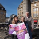 Ariane Hohengarten (Agentur für Arbeit) und Nina Jordan (Gleichstellungsbeauftragte) halten vor dem Reiterbrunnen das Job-Speeddating-Plakat in der Hand. Hinter ihnen steht Wirtschaftsförderer Thomas Ratte.