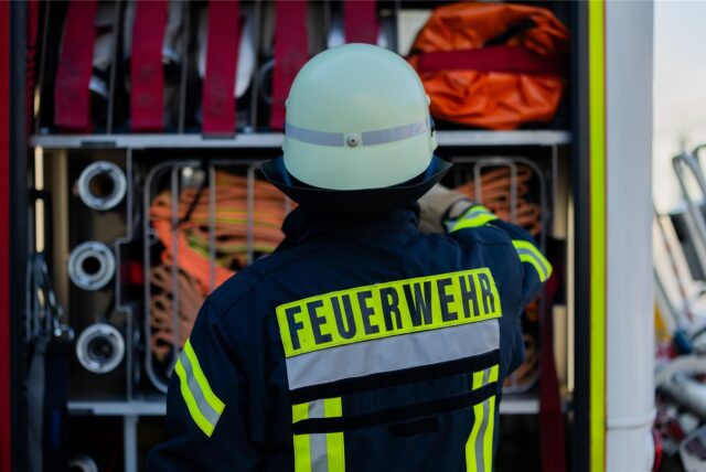 Ein Feuerwehrmann nimmt Ausrüstung aus einem Einsatzfahrzeug.