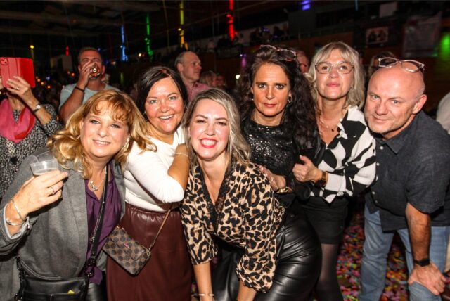 Gut gelaunte Frauen und ein Mann posieren für ein Gruppenfoto bei der 24. Aids-Gala in der Europahalle Castrop-Rauxel.